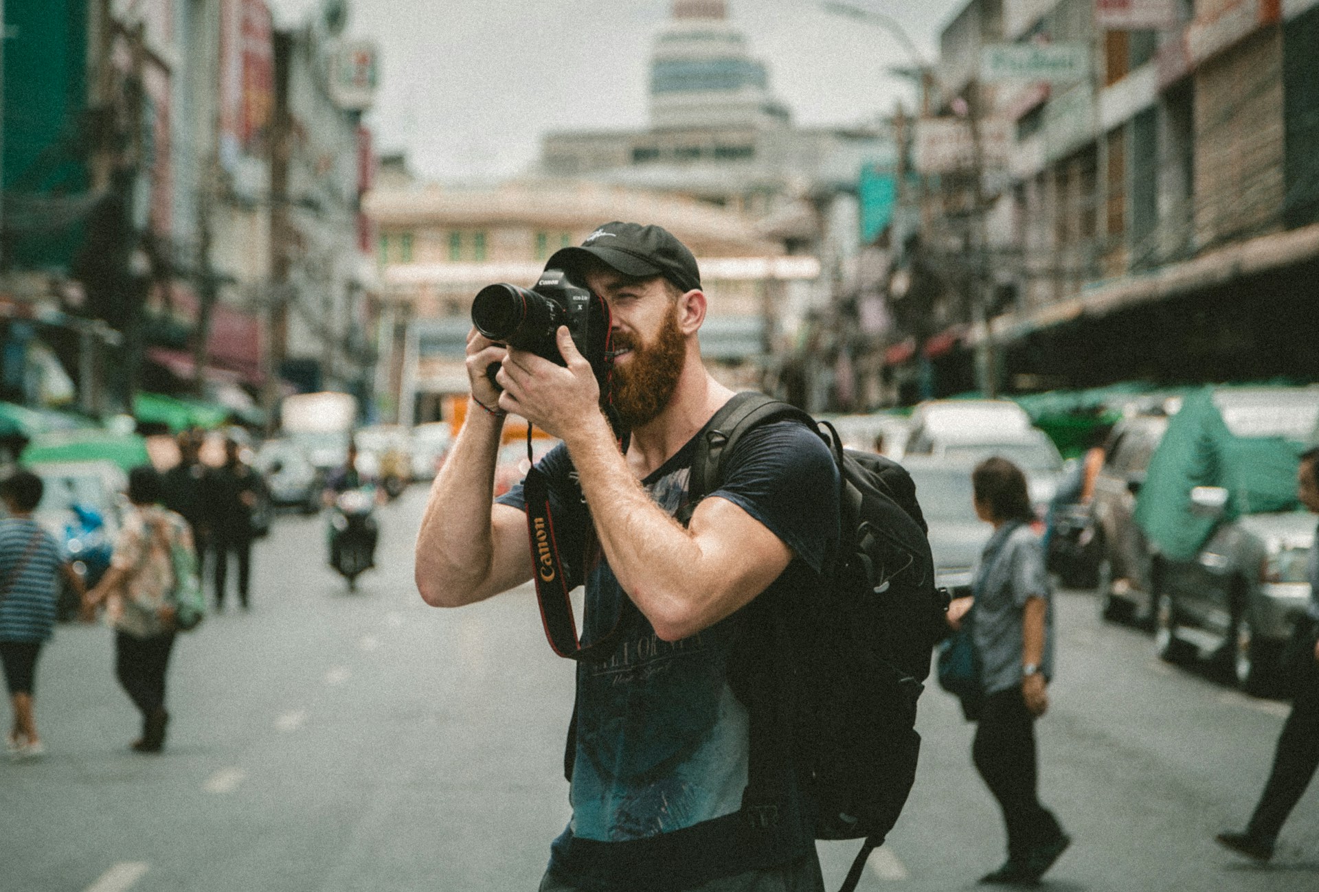 Fotógrafo com câmera na mão no meio da rua.
